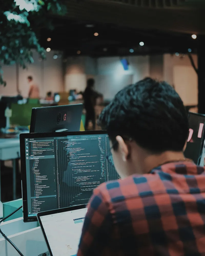 Engineer working through code on a large monitor
